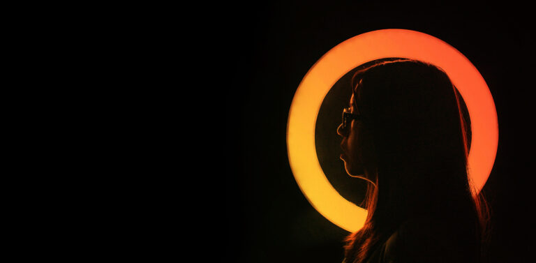 woman with a orange circle light behind