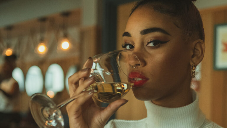 An African American woman drinks a non alcoholic wine